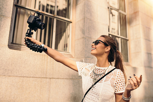 Young tourist recording selfie video while walking in the street.
