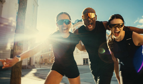 Running friends posing together outdoors after run club workout in the city