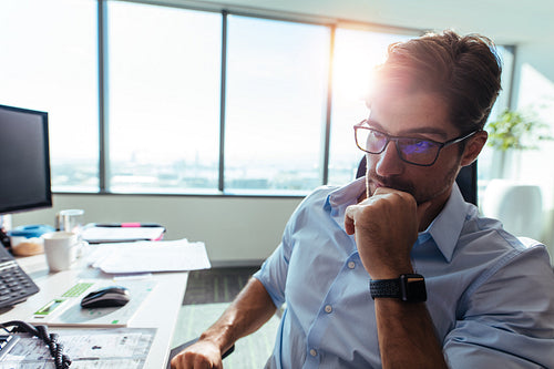 Businessman sitting at his desk in office.