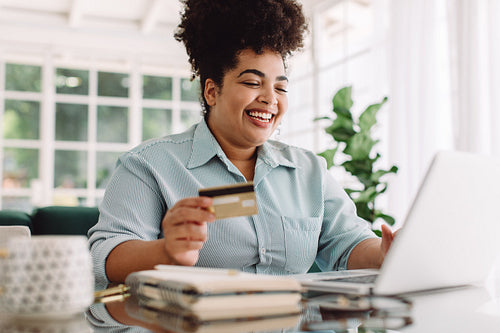 Smiling woman at home doing online payment
