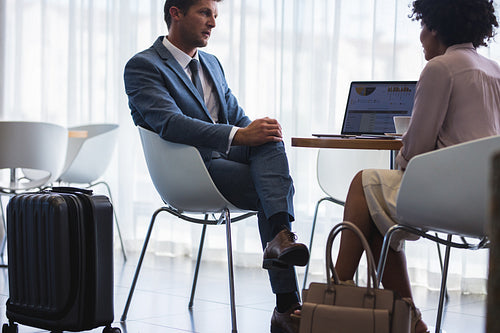 Business colleagues discussing at airport lounge