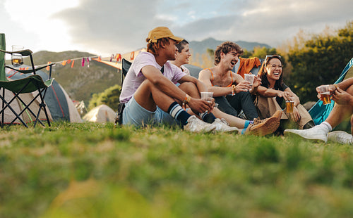 Friends gather together at a summer festival, sharing laughter, enjoying beers, and making joyful memories