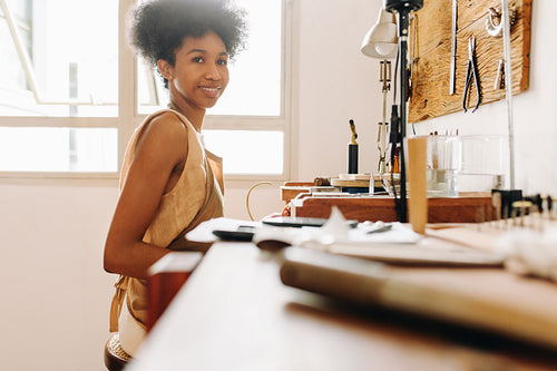 Happy female jeweler in her studio