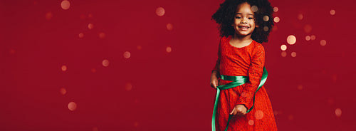 Little girl playing with a satin ribbon