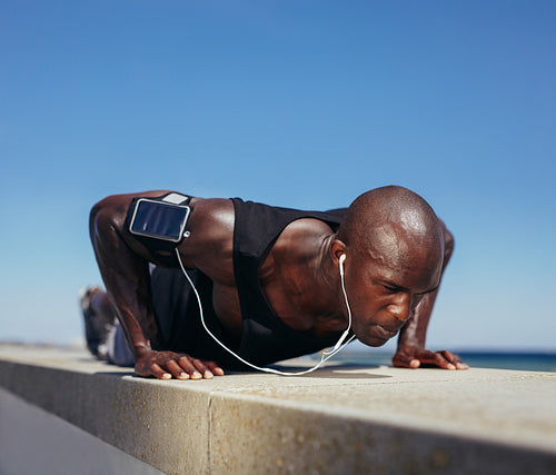 Sporty man doing push-ups outdoors