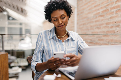 Small business owner using a smartphone in a warehouse
