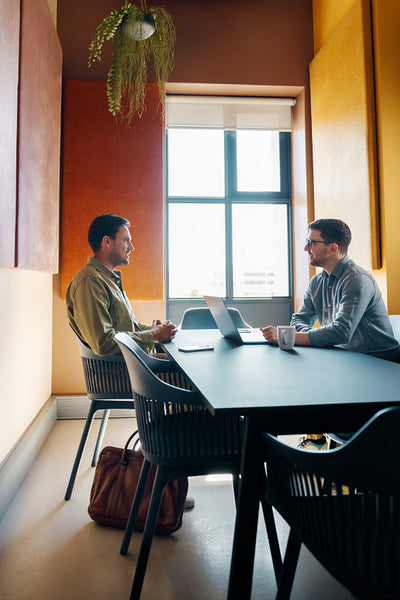 Two professionals engaged in a discussion in a modern office setting