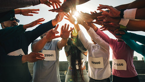Group of runners united with hands in the center