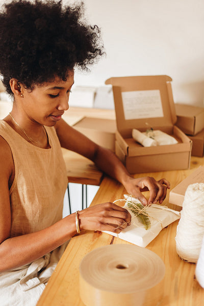 Artist putting lace on ornament parcel