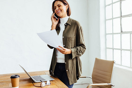 Business communication: Professional woman talking on the phone at work