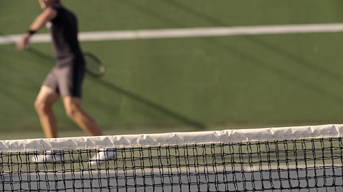 Tennis player practicing forehands on hard court