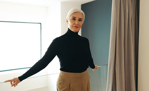 Mature business woman standing on an office balcony in business attire
