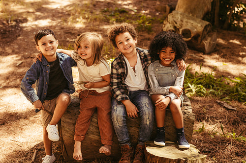 Group of kids on a wooden log 