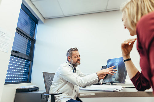 Doctor explaining x-ray to female patient