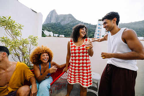 Friends enjoying drinks together on a rooftop during a sunny day