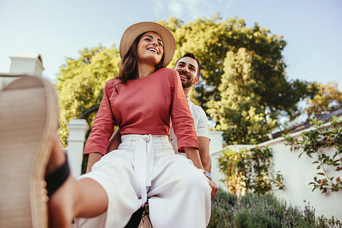 Young couple smiling cheerfully on a bike outdoors