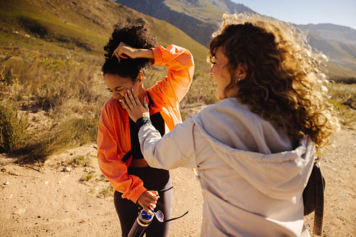 Friends applying sunscreen during a mountain hike