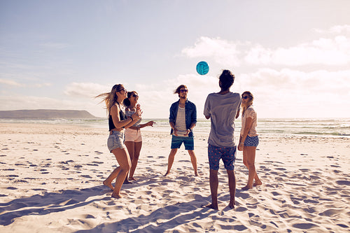 Young people playing with ball at the beach