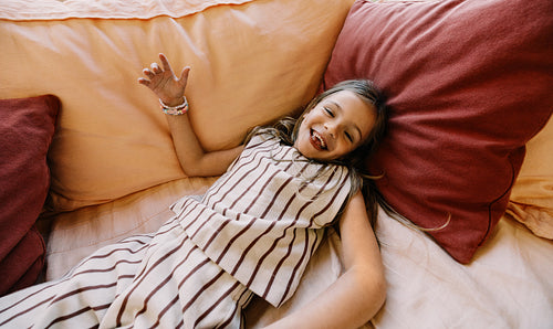 Girl smiling on couch with striped dress