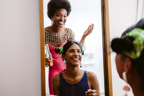 Carnival friends laugh in mirror