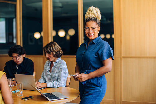 Smiling professional black woman in a bright office during a team meeting