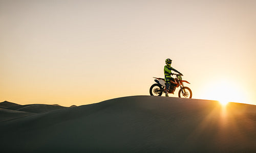 Motocross biker on his bike in desert