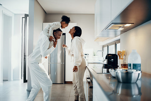 Happy family moments at home, mom and dad are playing with their daughter in the kitchen