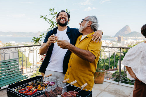 Latin American family enjoying a Brazilian barbecue with scenic city view