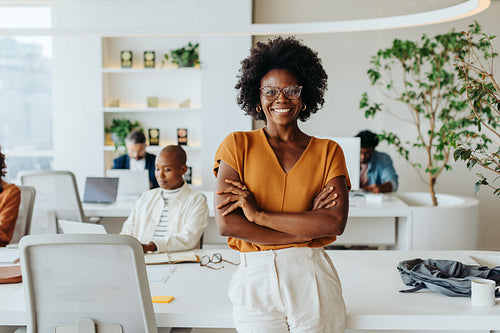 Confident black woman with afro hair smiling in a startup office