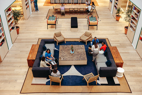 Overhead view of modern office lounge with people engaging in conversation