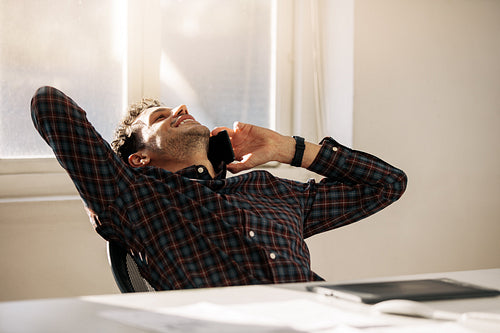 Businessman talking over mobile phone in office