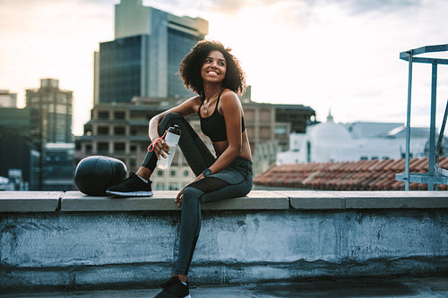 Woman athlete taking break from workout drinking water