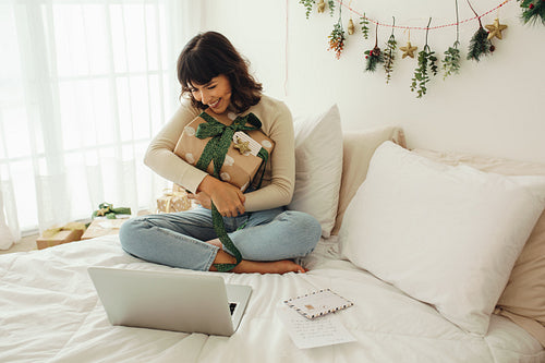 Smiling woman hugging her christmas gift on a video call
