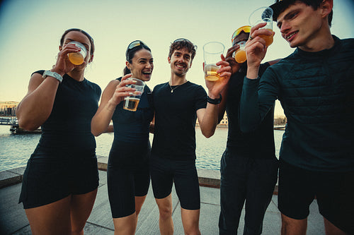 By the waterfront, running friends gather with beer after a run
