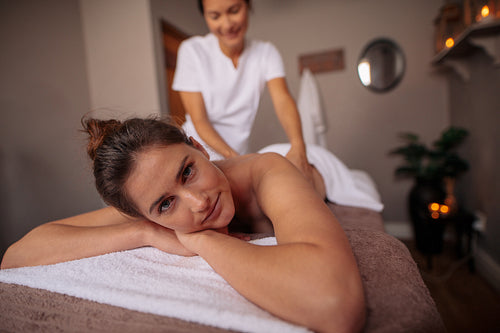 Woman receiving back massage at spa center