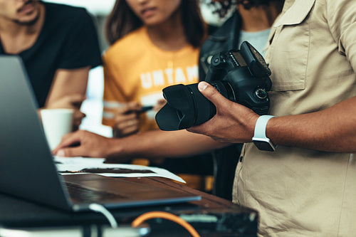 Photographer reviewing the photo shoot with his team on a laptop