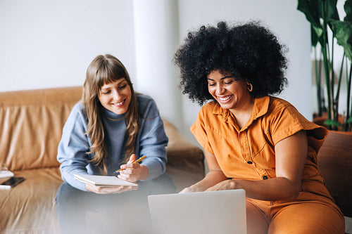 Happy young businesswomen having an online meeting in a lobby