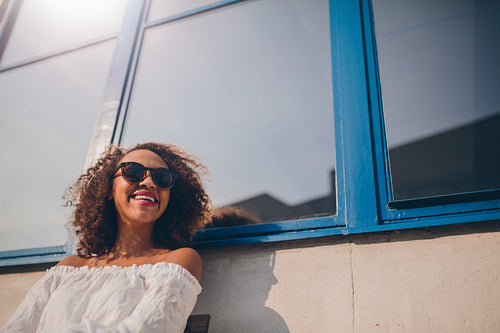 Smiling young african woman sitting outdoors