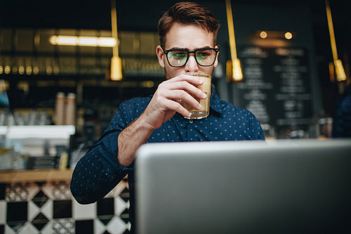 Businessman sitting at a restaurant working on laptop