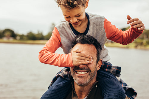 Father and son playing near the lake
