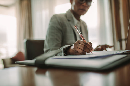 Female at hotel room desk making notes