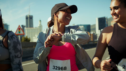 Female marathon runners checks her smartwatch