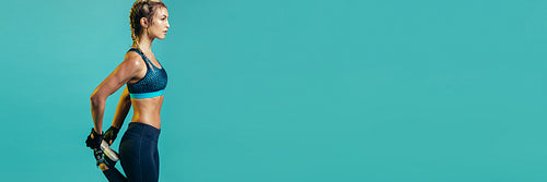 Female runner doing stretches on blue background