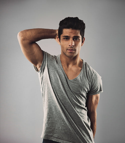 Handsome young man posing against grey background