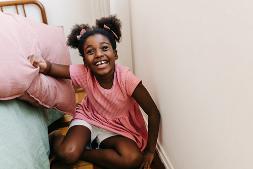 Playful black girl getting excited for a pillow fight