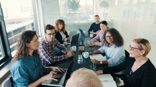 Presentation in a business meeting: Professional people sitting in a boardroom and listening to a speaker