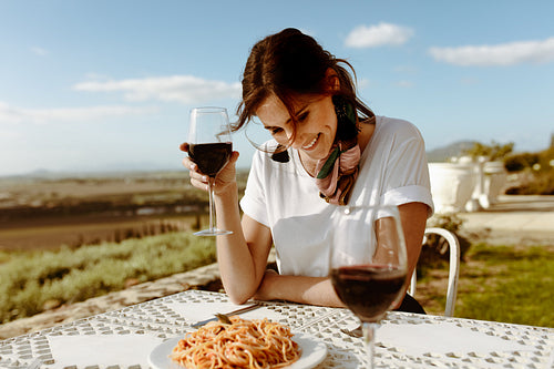 Woman sitting at a dining table drinking wine