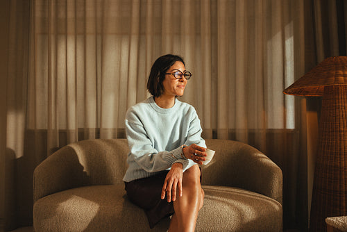 Woman pauses from work with coffee in her private office workspace