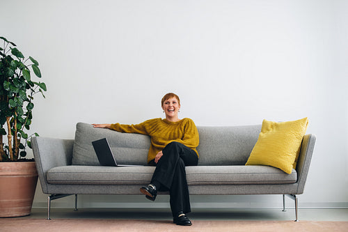 Confident executive sitting on sofa with laptop
