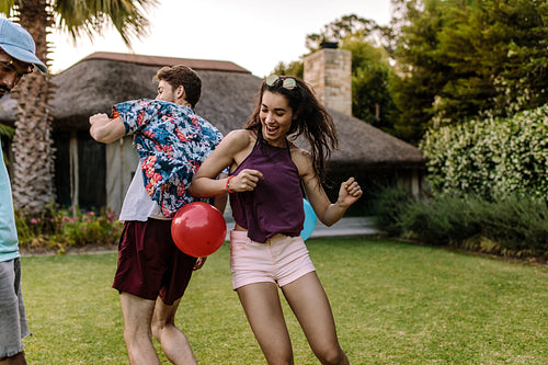 Friends playing balloon popping games at party
